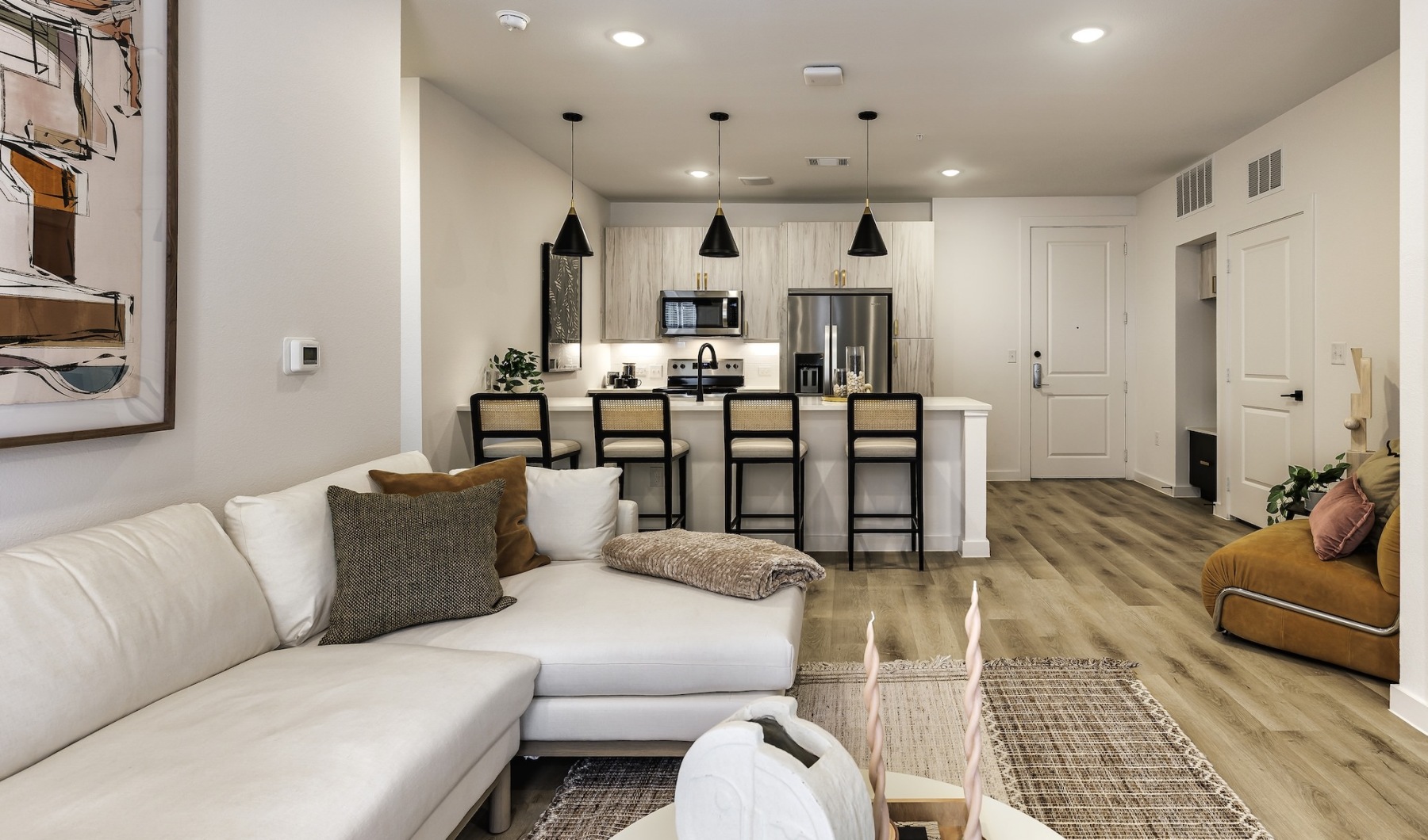 Spacious living room with a white couch at Rivette Tower apartments in Austin. Spacious living room with a white couch at Rivette Tower apartments in Austin.